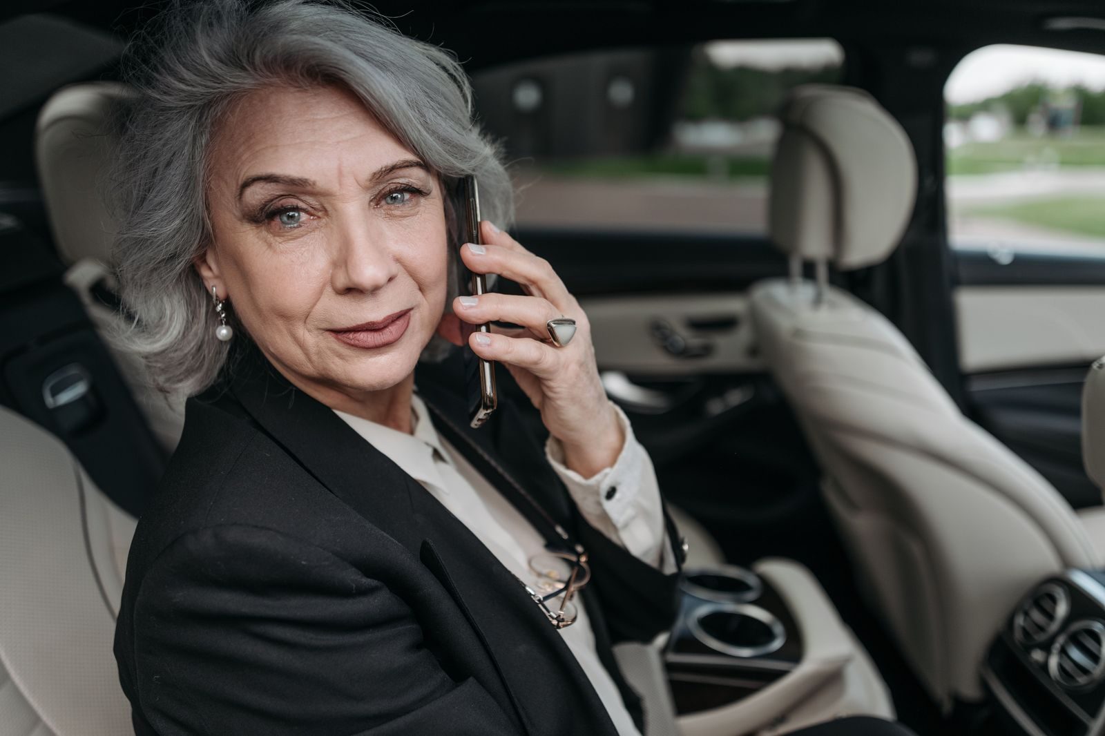 A business traveller seated in the back of a car looking out of the window at the city