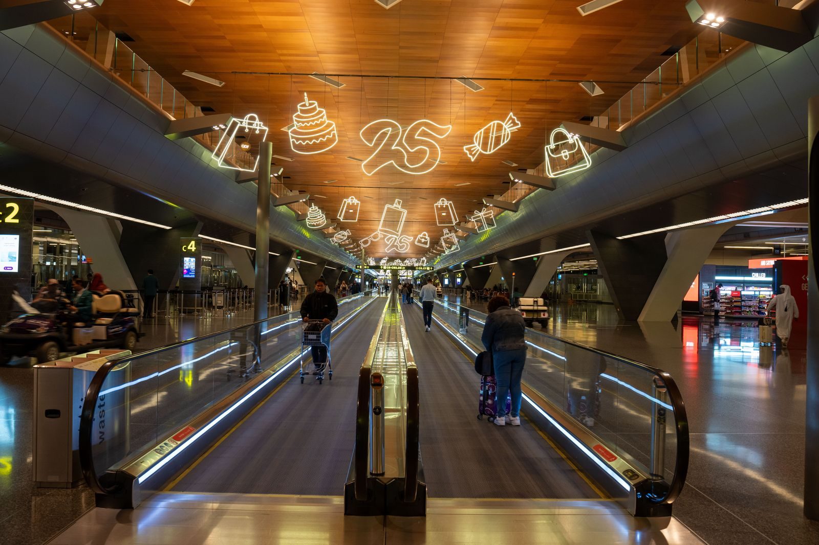 A traveller with a suitcase walking through an airport terminal towards the arrivals exit
