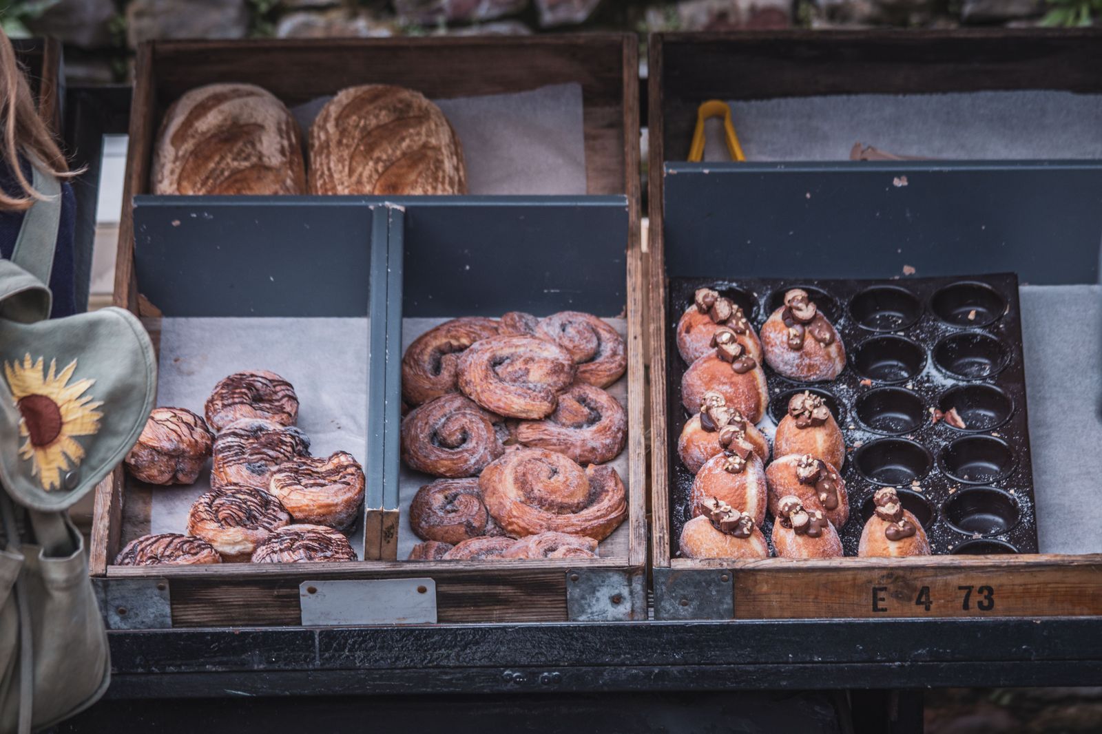Fresh bread and baked goods on a market stall, the kind of purchase that makes a waiting car worth having on a Saturday morning