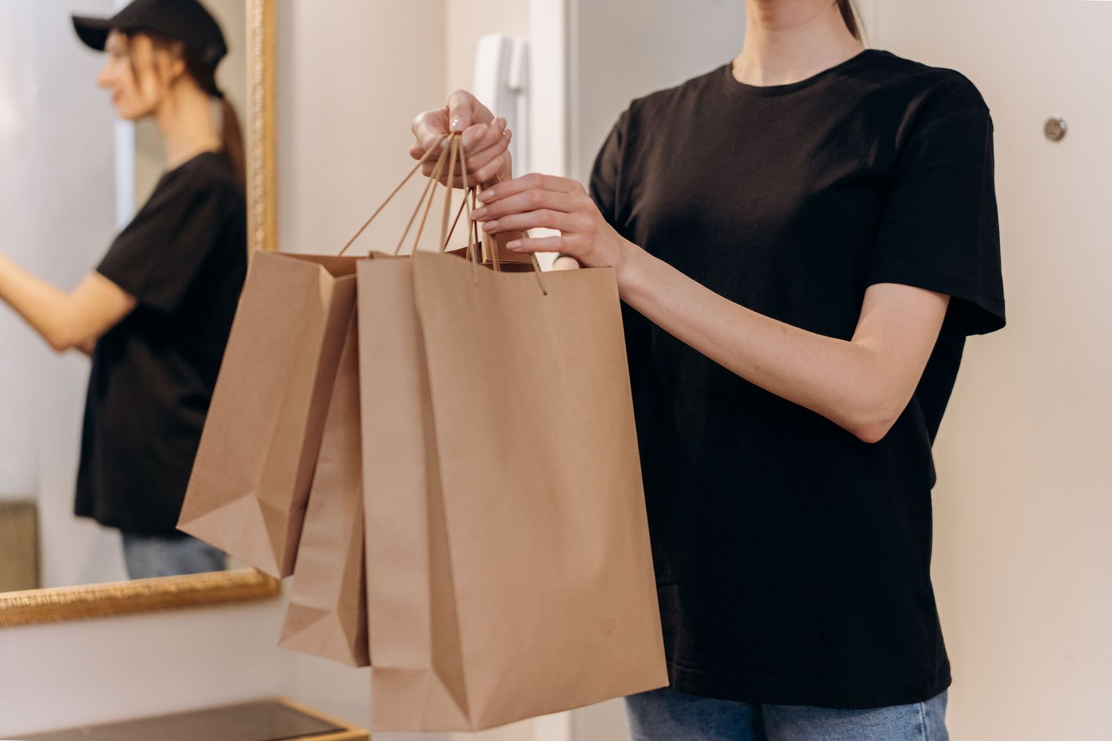 A shopper carrying market bags along a street, the end-of-morning scene a chauffeur can make much lighter