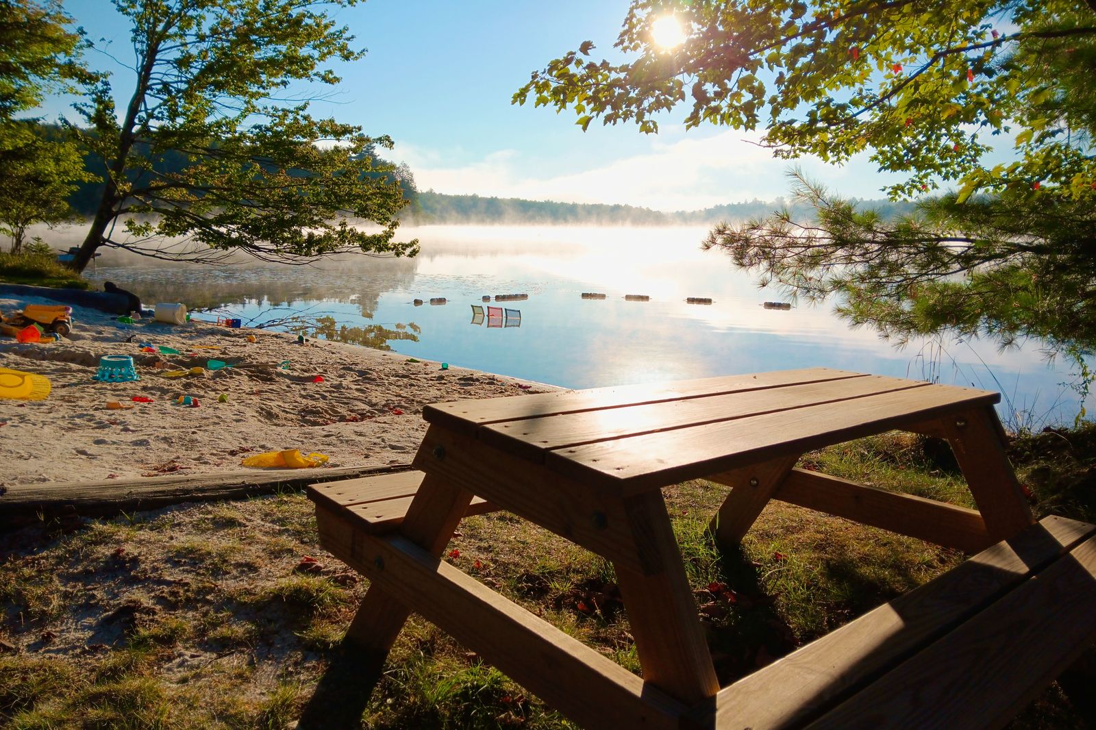 A family setting out a picnic on a lakeside beach, a typical group booking for a car that waits on the Barrie waterfront