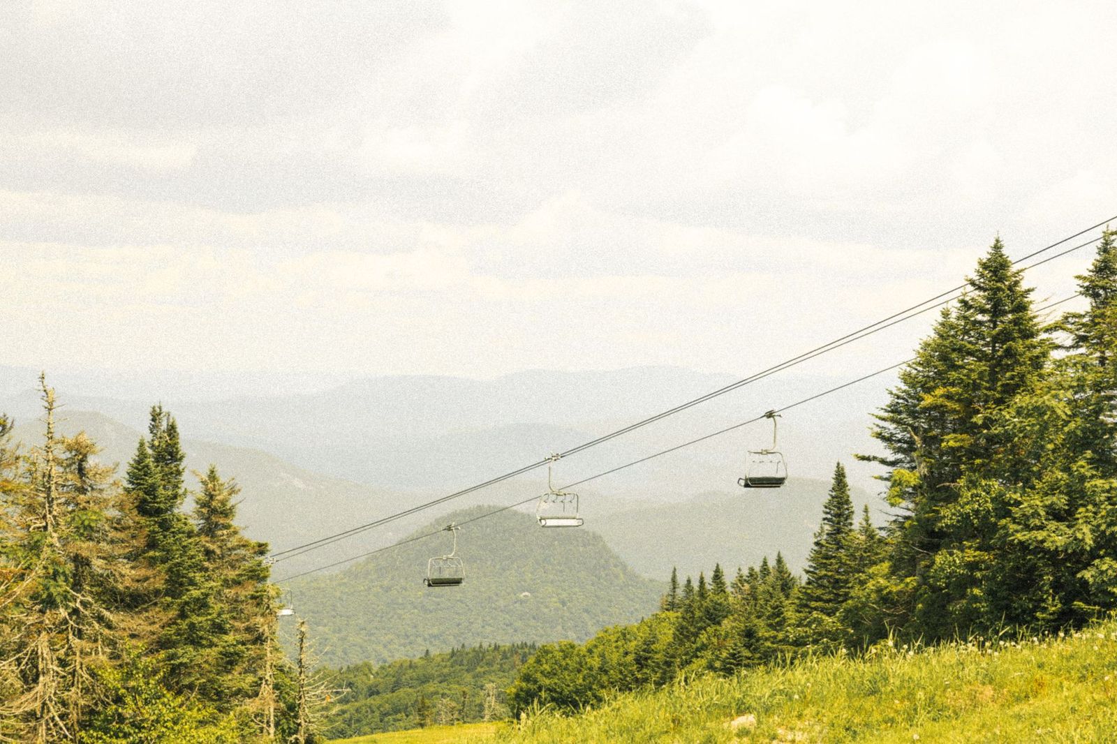 The open-air gondola and mountain views that draw summer visitors to Blue Mountain Village