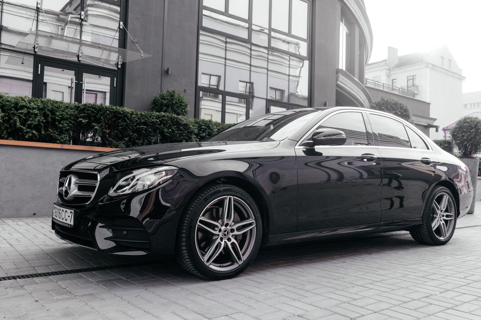 A black sedan waiting outside a lit resort entrance at night, the kind of door-to-door ride a casino evening calls for