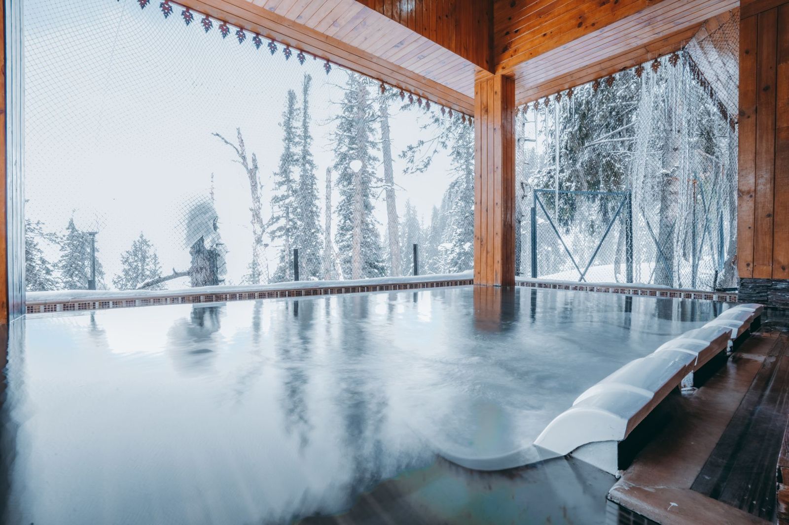 Steam rising from an outdoor spa pool in winter, the draw of a Nordic spa afternoon