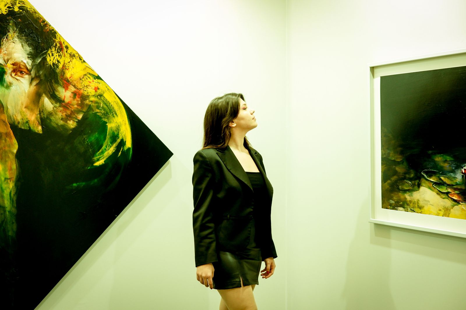 Gallery visitors looking at paintings on a white wall, the kind of unhurried visit an hourly chauffeur is built around