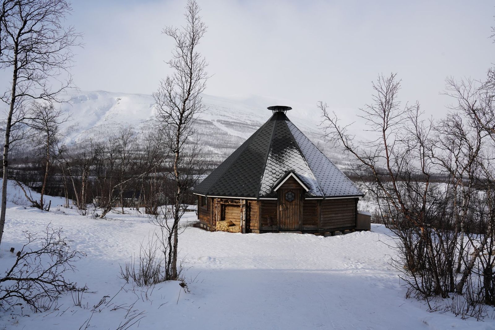 A wooden sauna among snowy trees, the heat stage of a Nordic thermal circuit