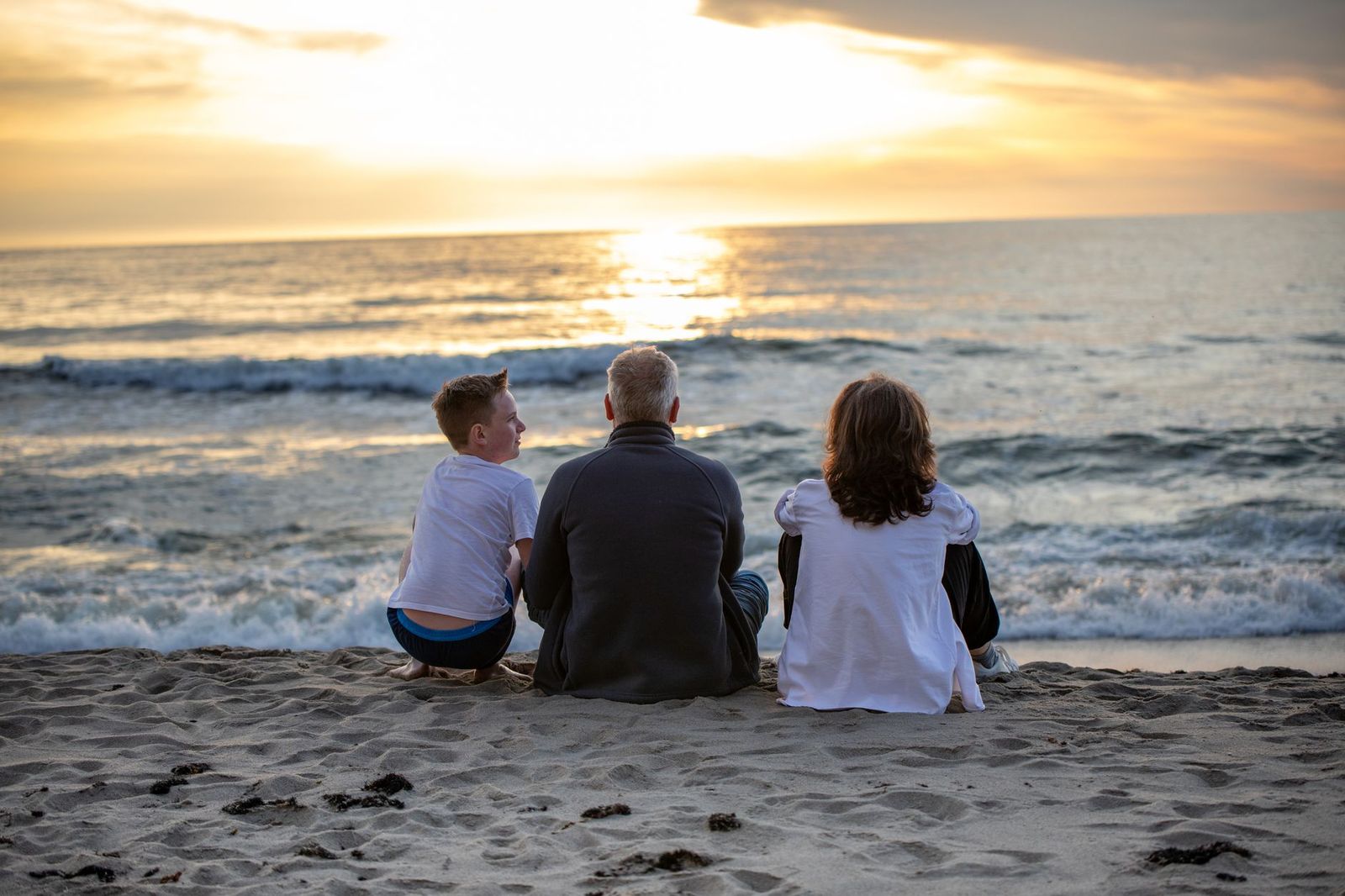 A family settling onto the sand at sunset on the Wasaga Beach shoreline