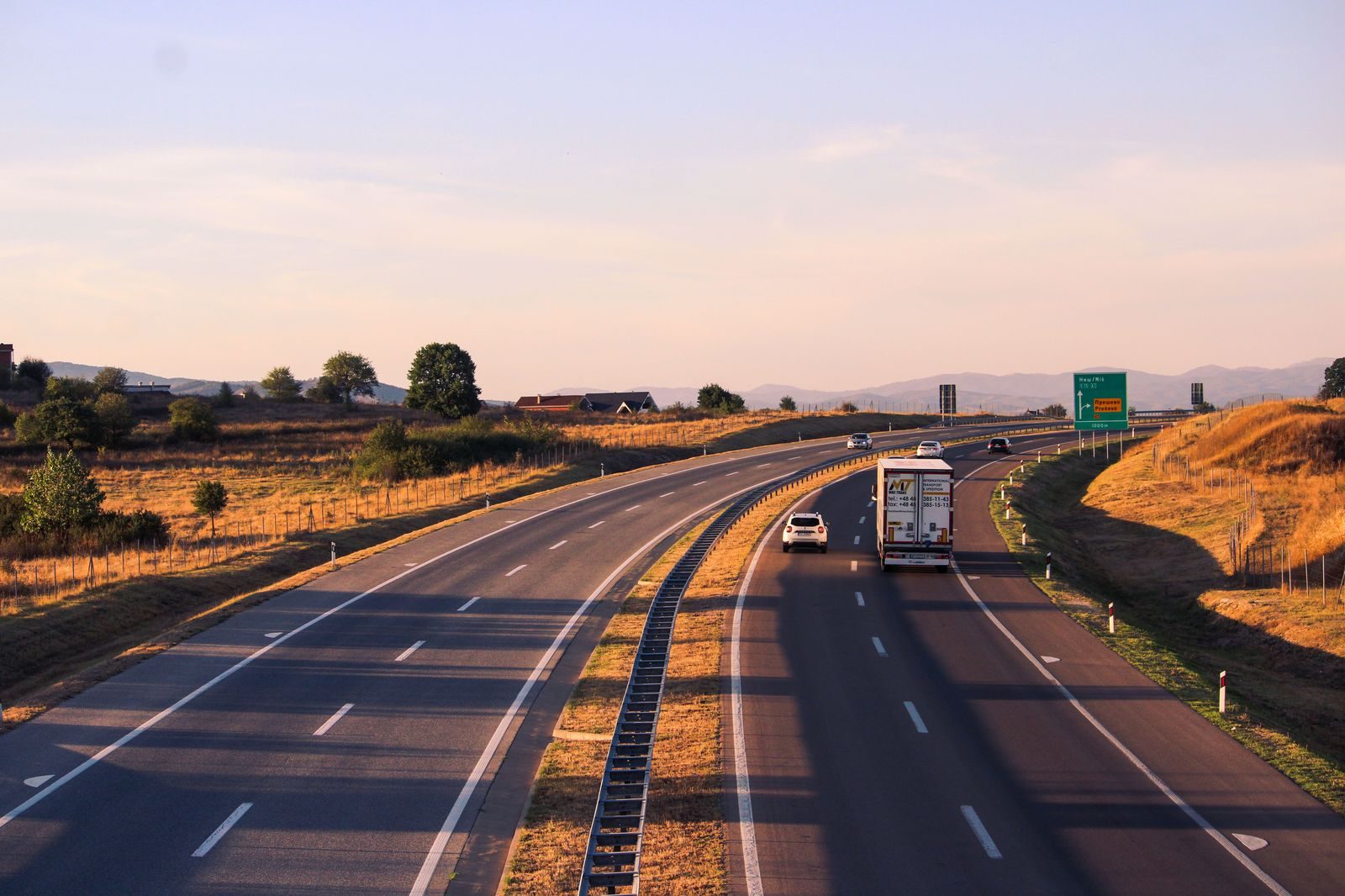 A chauffeur-driven black sedan on a multi-lane highway