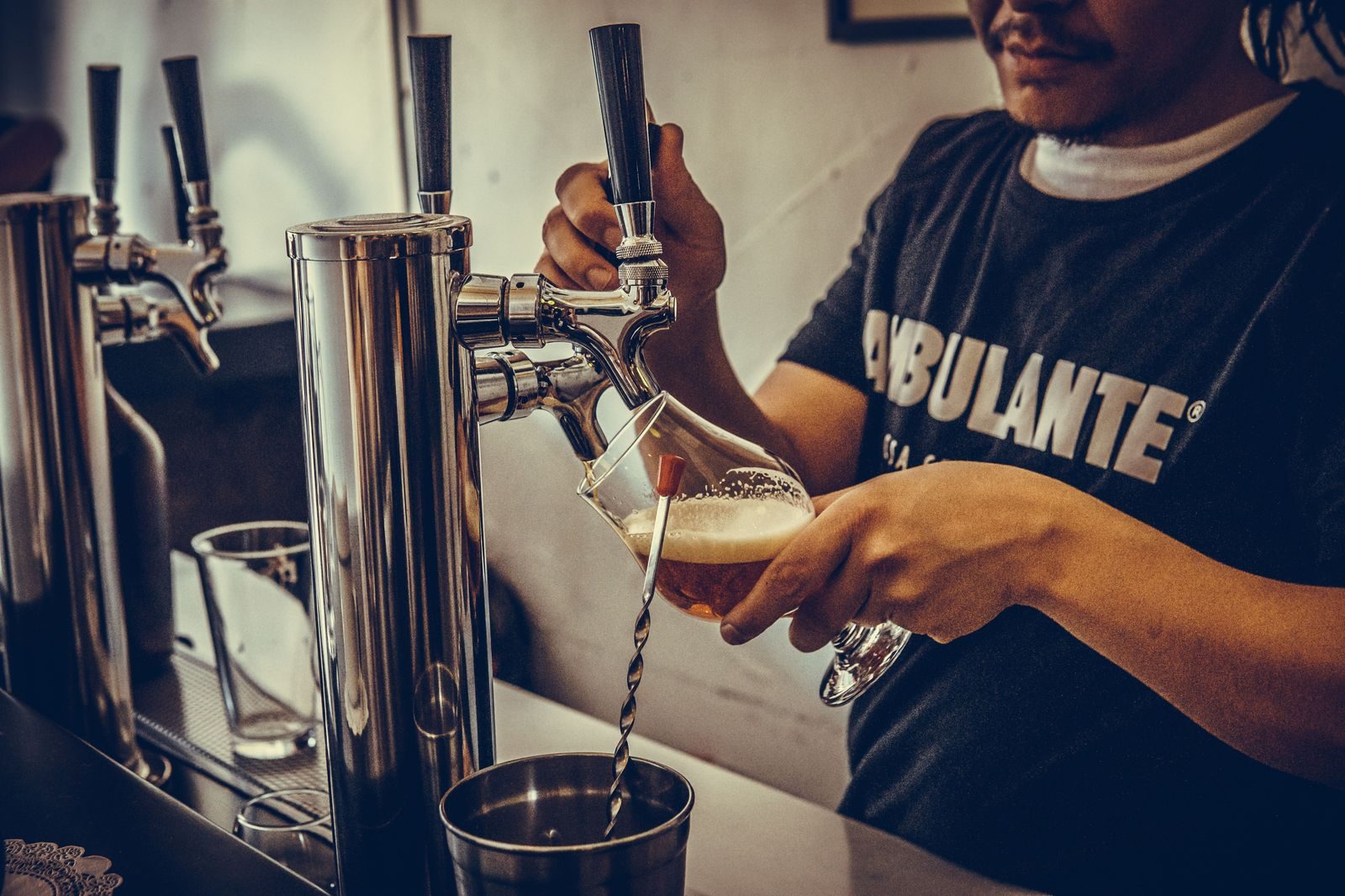 A row of taps behind the bar in a craft brewery taproom