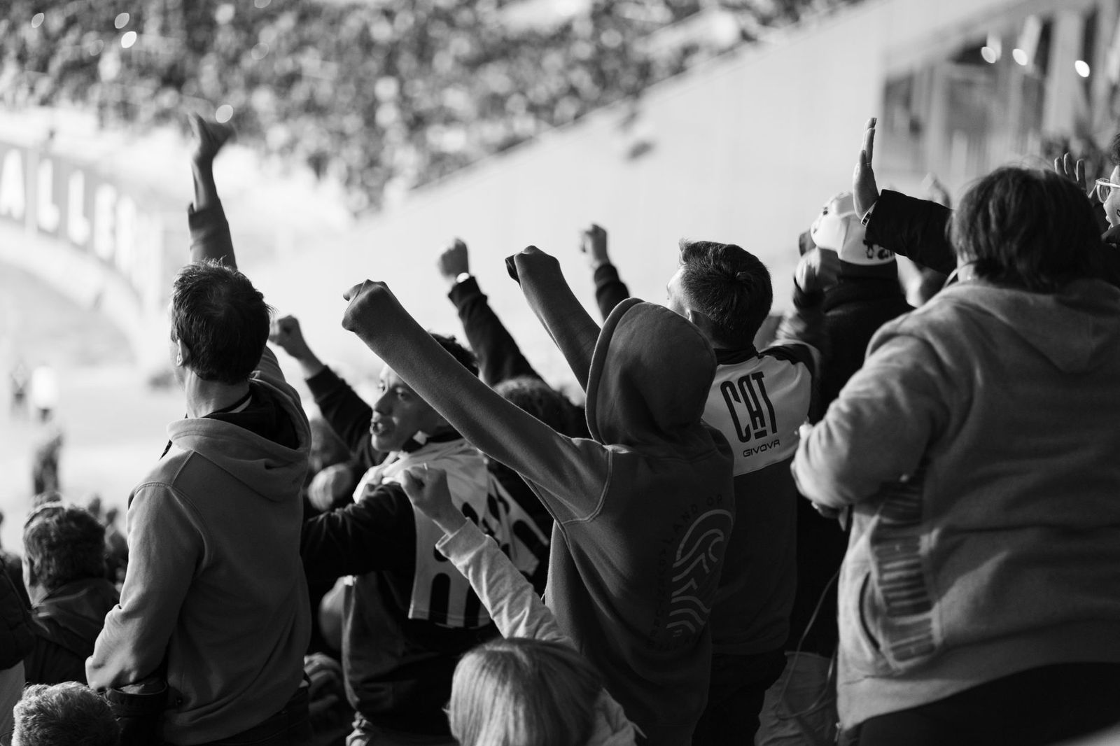 Football fans in winter coats walking toward a stadium