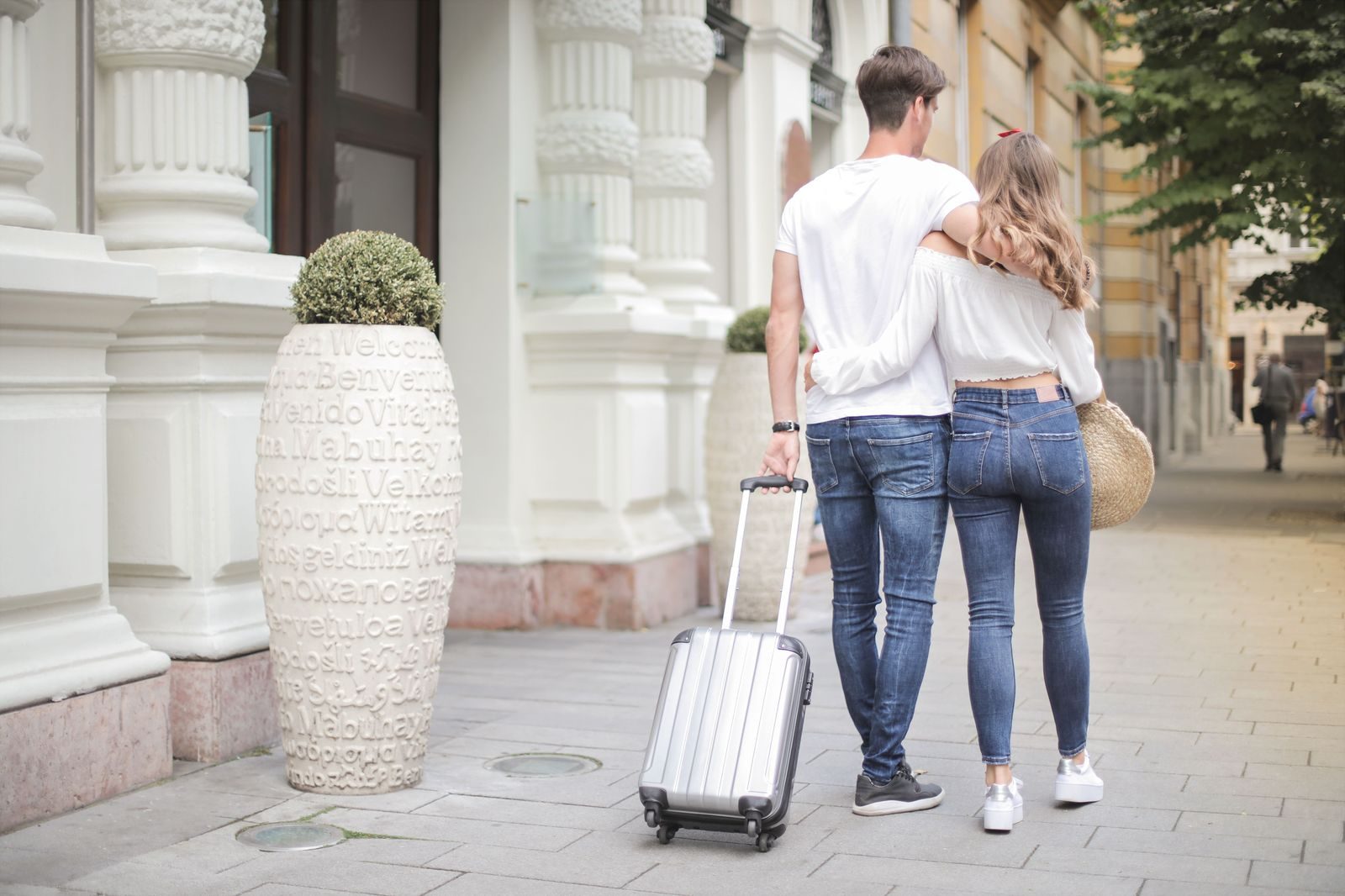 A family with suitcases at an airport departures curb
