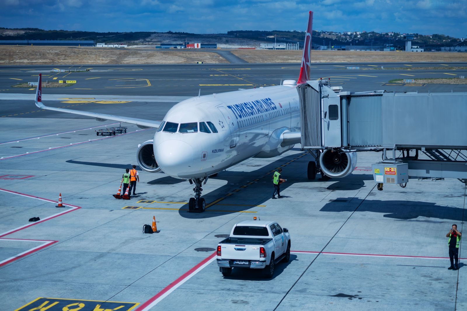 A black SUV waiting curbside at an airport terminal