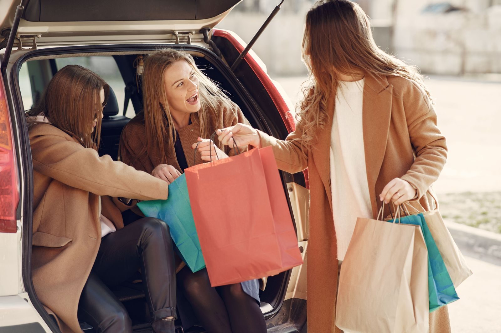 Shopping bags loaded into the back of a black SUV after an outlet day