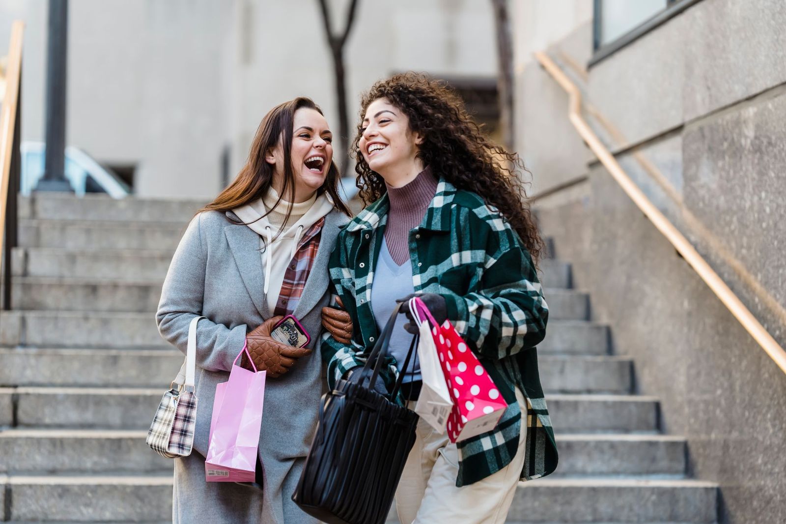 Friends laughing with shopping bags after a day at an outlet centre