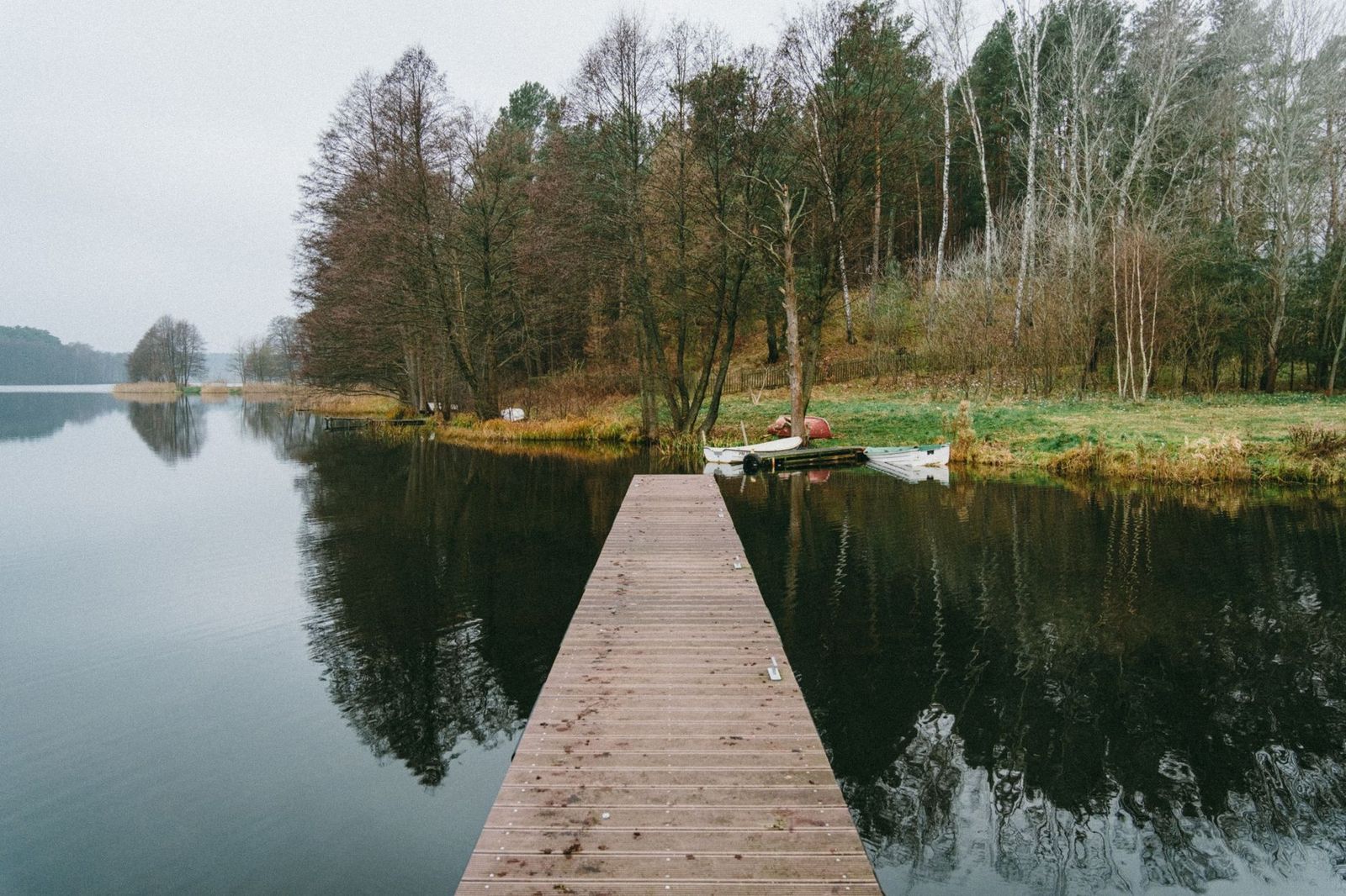 A cottage dock in October with fallen leaves on the lake, the sign that closing weekend is near