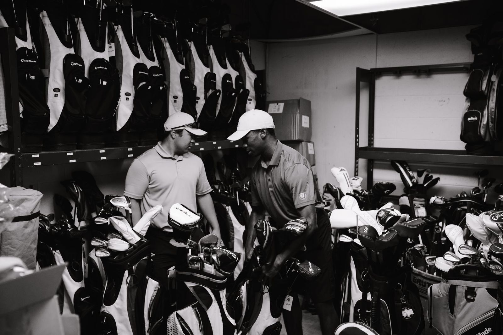 Golf bags loaded into the back of a black SUV outside a clubhouse