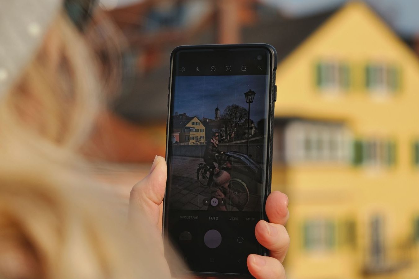 A passenger checking a ride app on a phone on a Barrie street corner