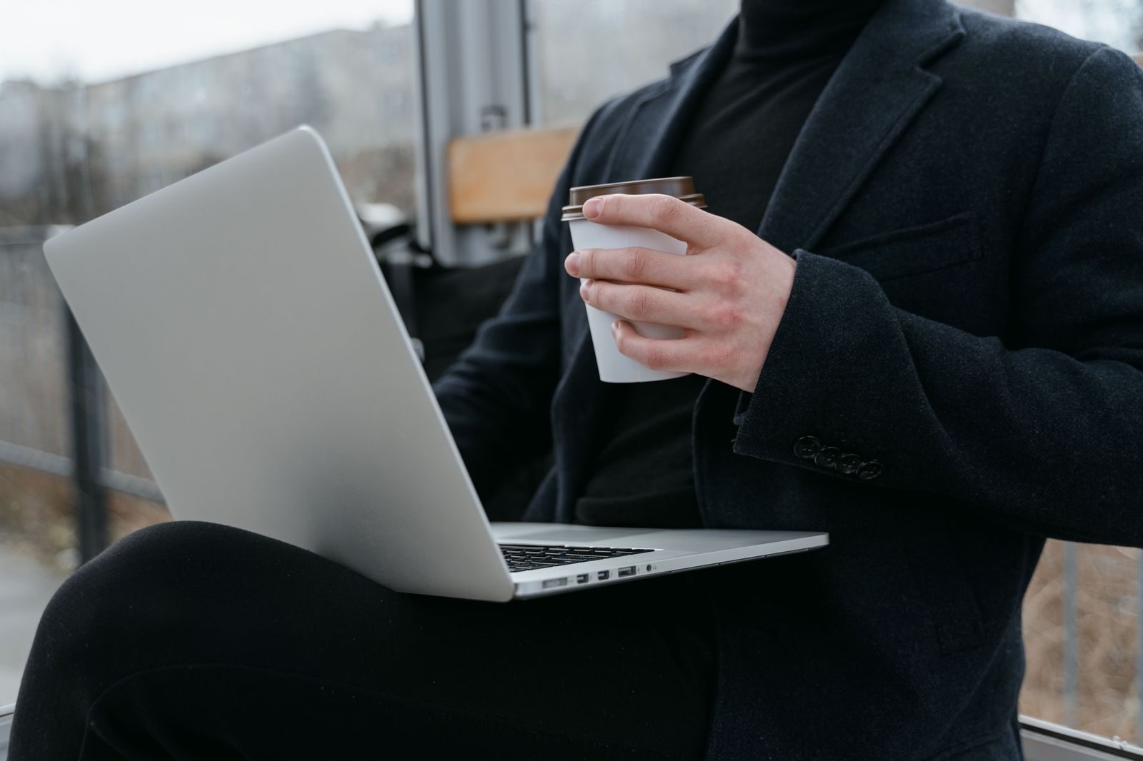 An executive working on a laptop in the back seat of a luxury car