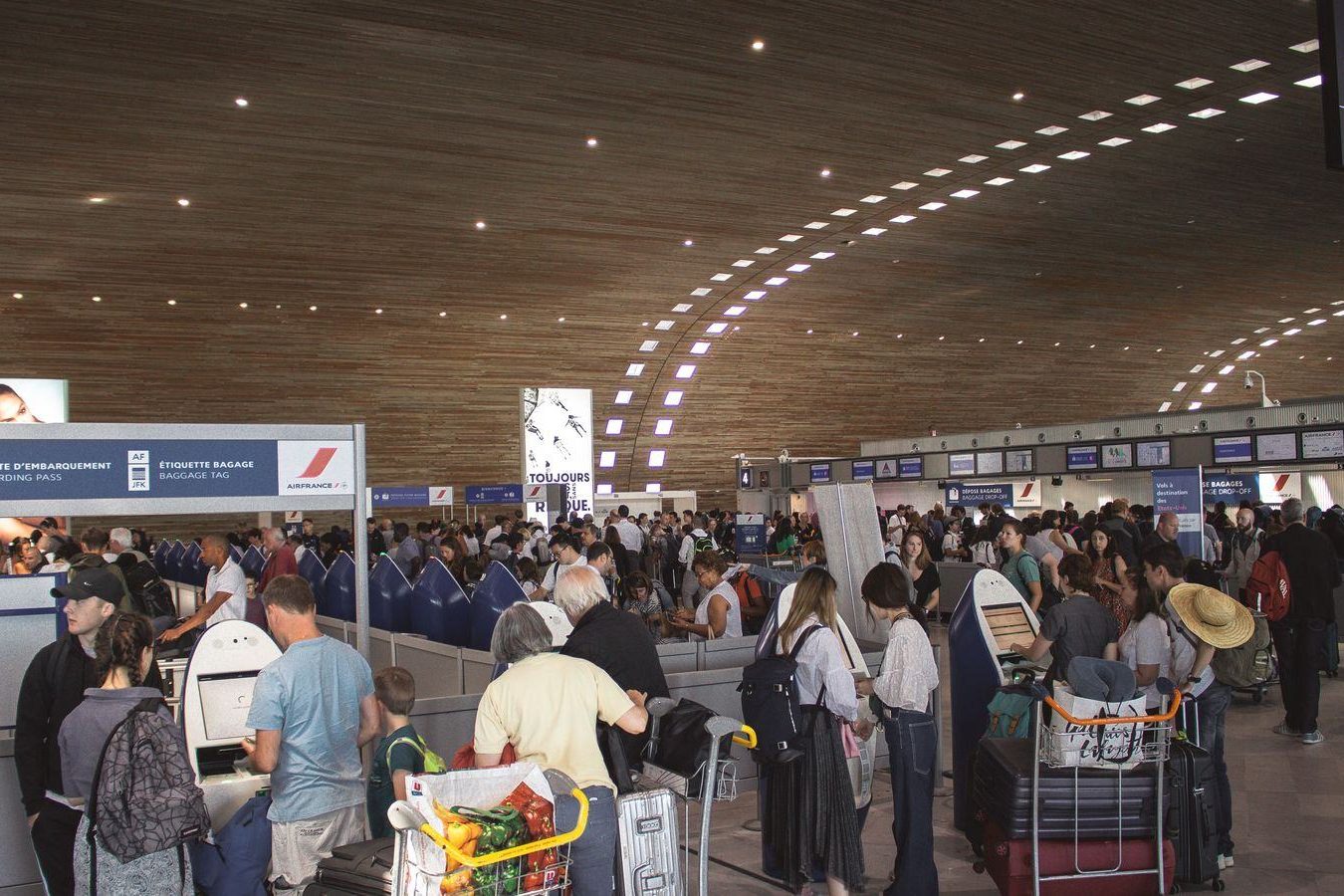 A chauffeur holding a name board in an airport arrivals hall