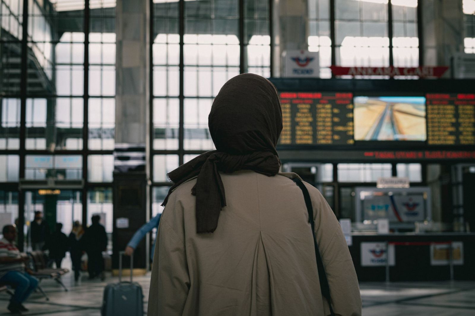 Travellers waiting beneath a departures board showing delays