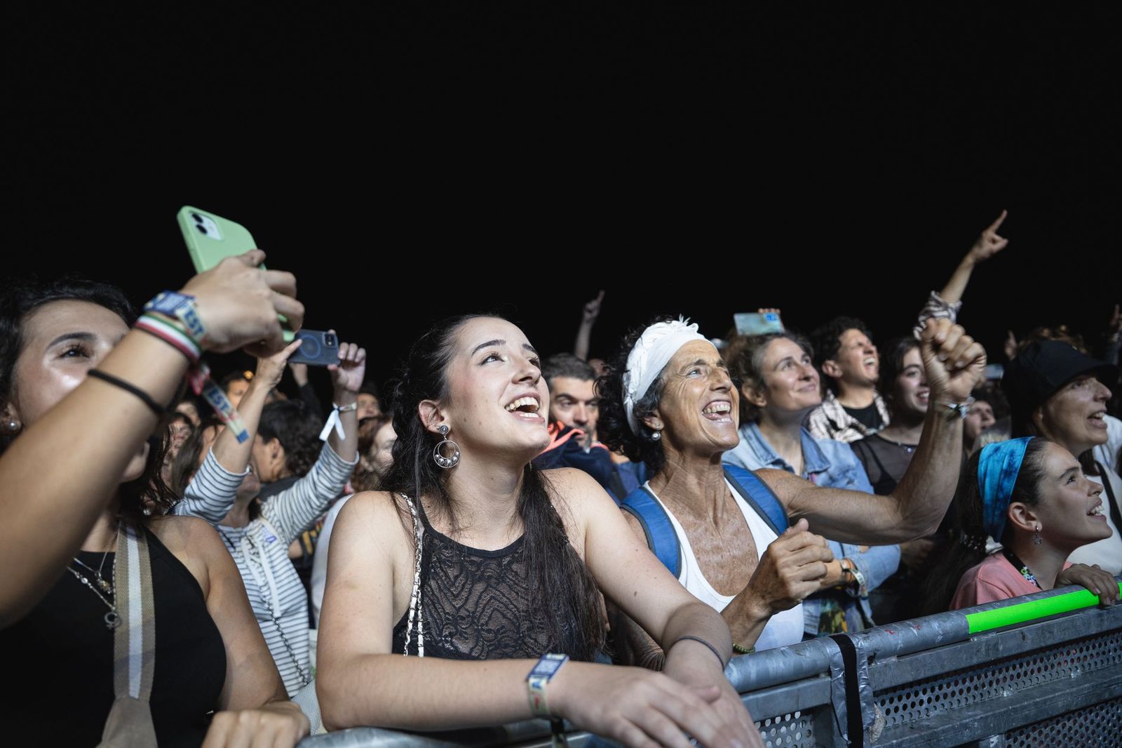 Concert fans under stage lights at an outdoor show