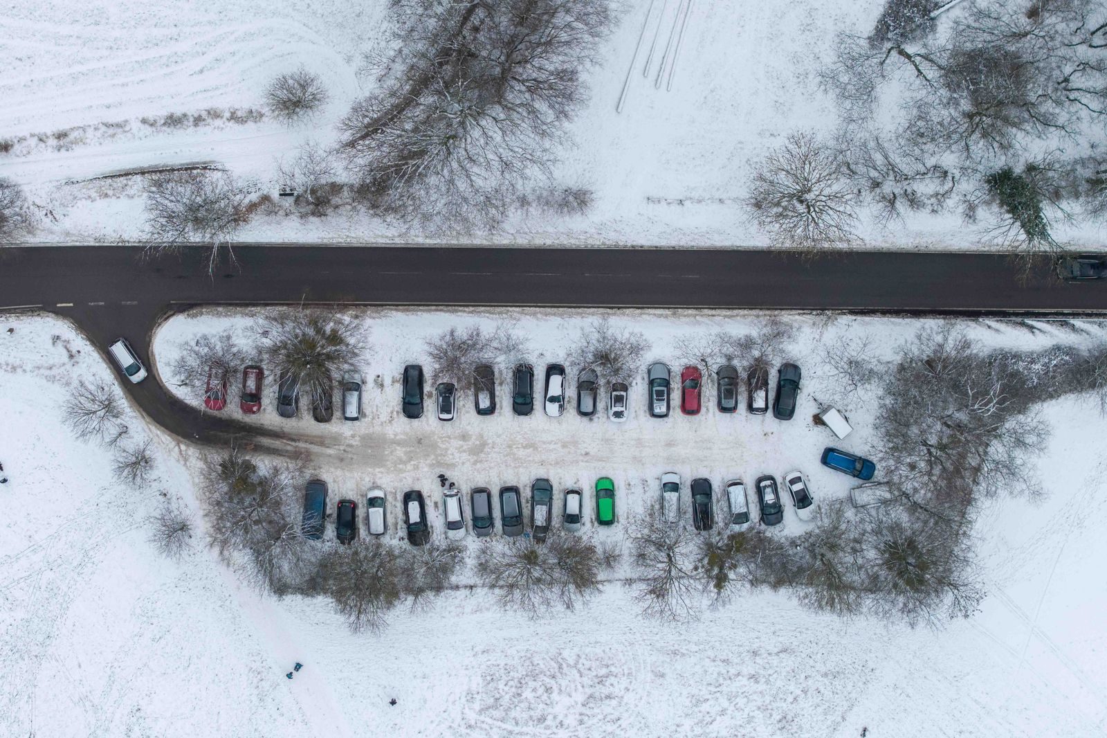 A snowy arena car park lit by floodlights on a winter evening