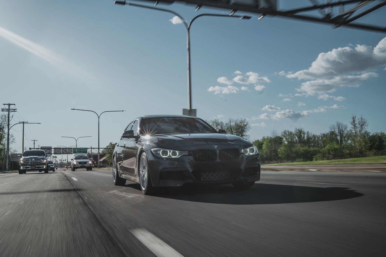 A sedan driving along a snow-covered highway