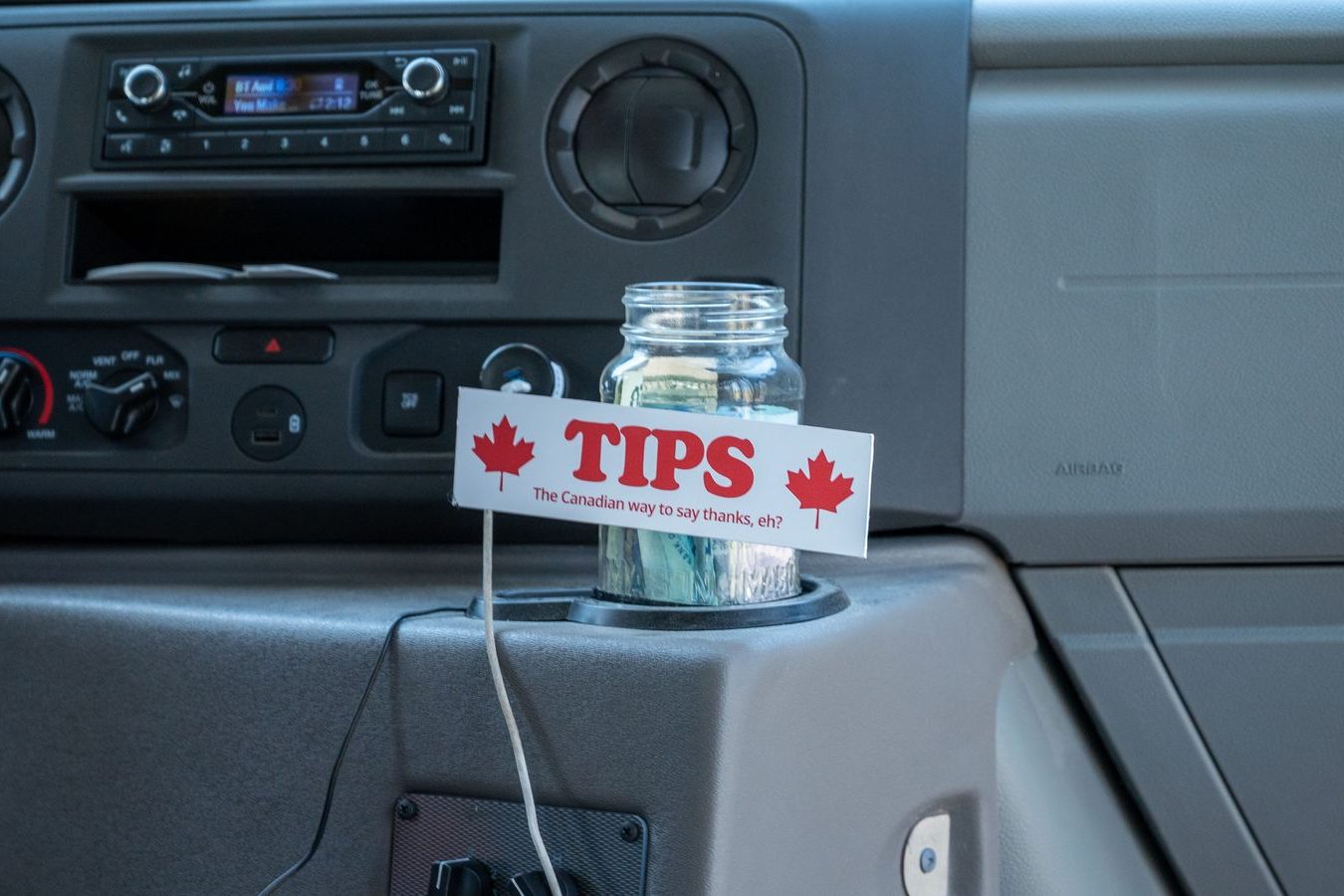 Folded bills held out at the end of a ride: a gesture that an all-in fare makes unnecessary