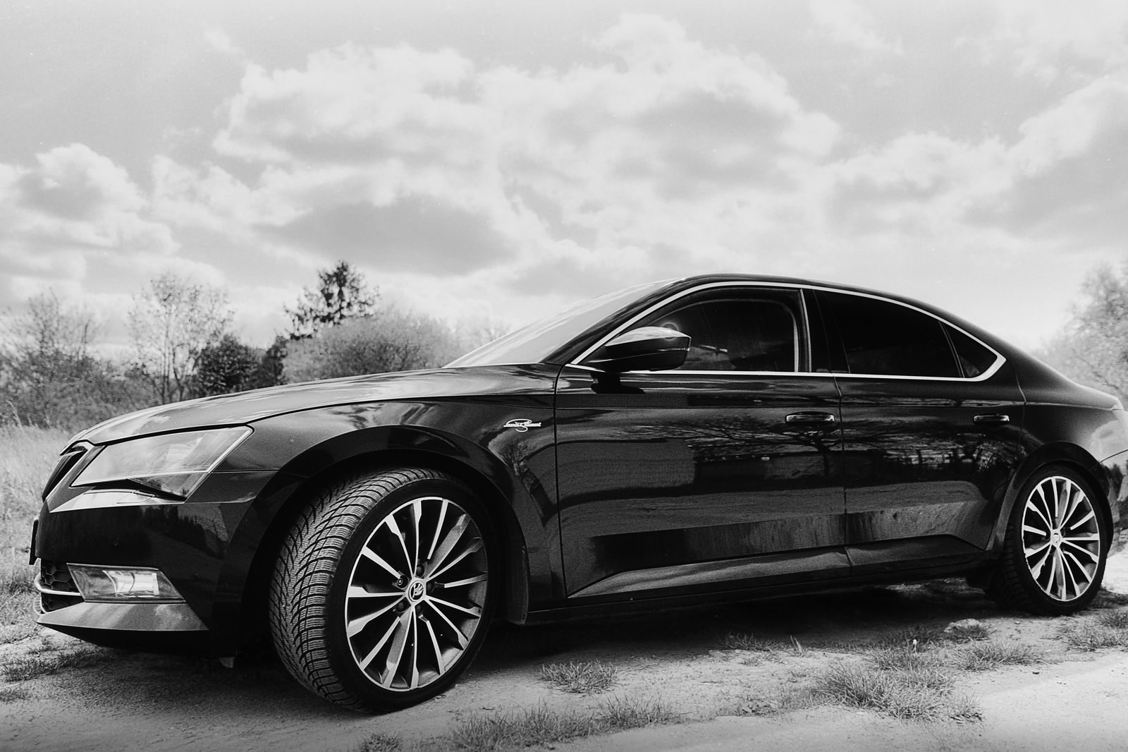 A black sedan and chauffeur waiting for an airport pickup