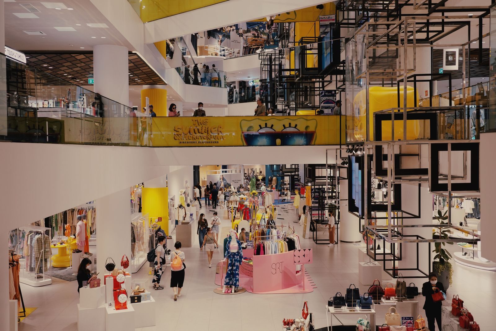 A family walking through a busy indoor shopping mall in the evening