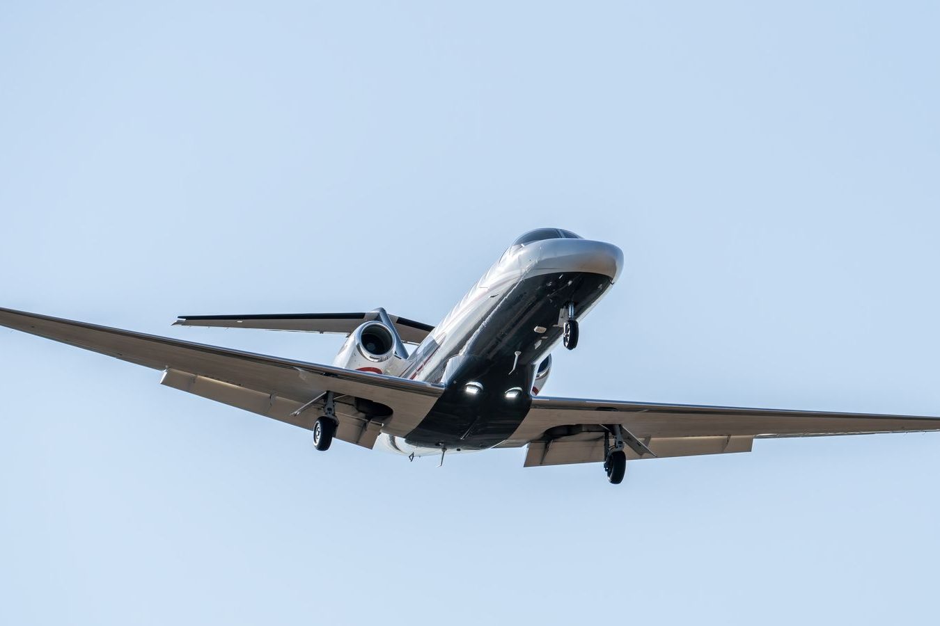 A business jet landing on a long runway on a clear day