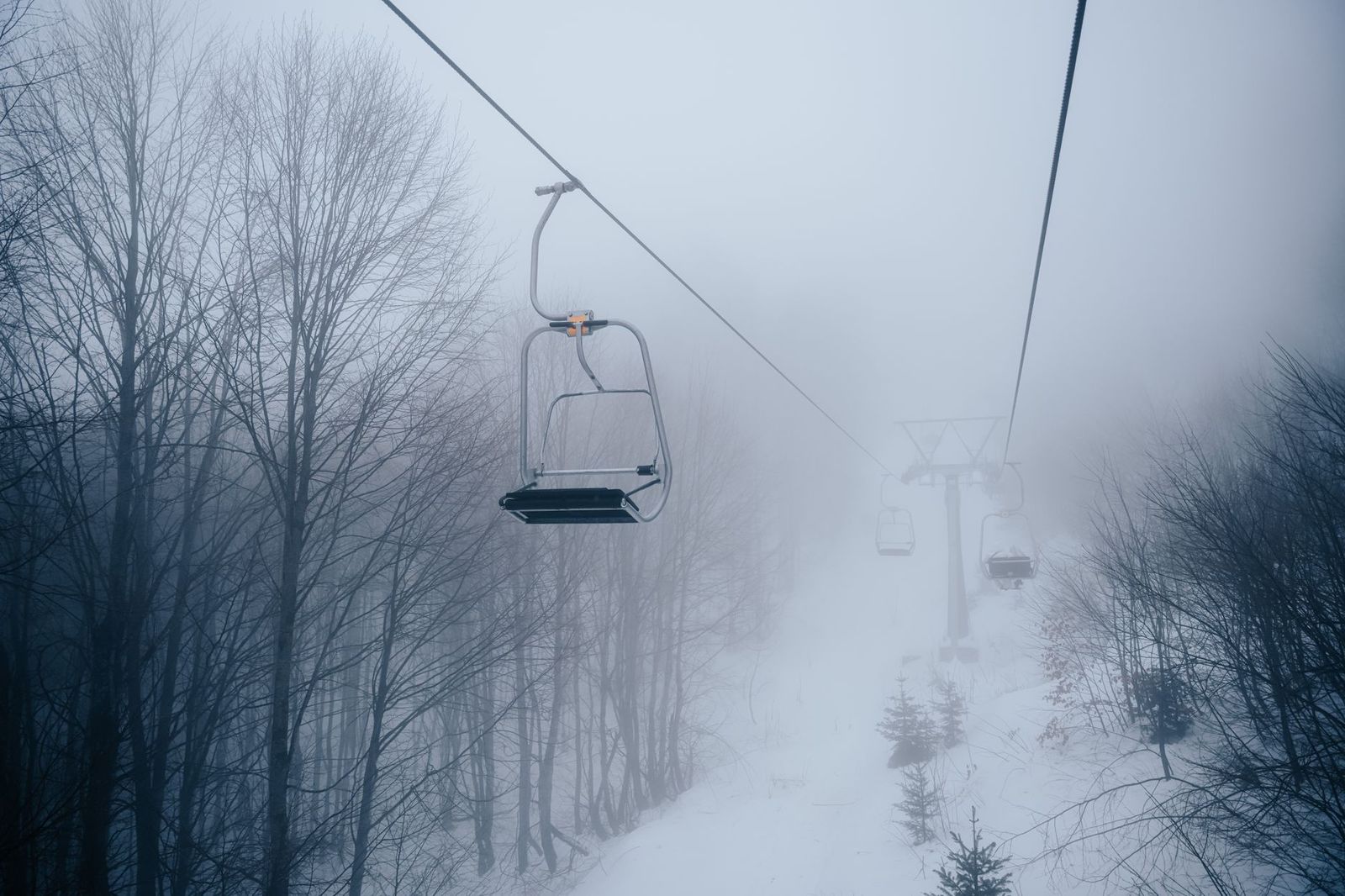 Skiers on a chairlift above Collingwood in winter