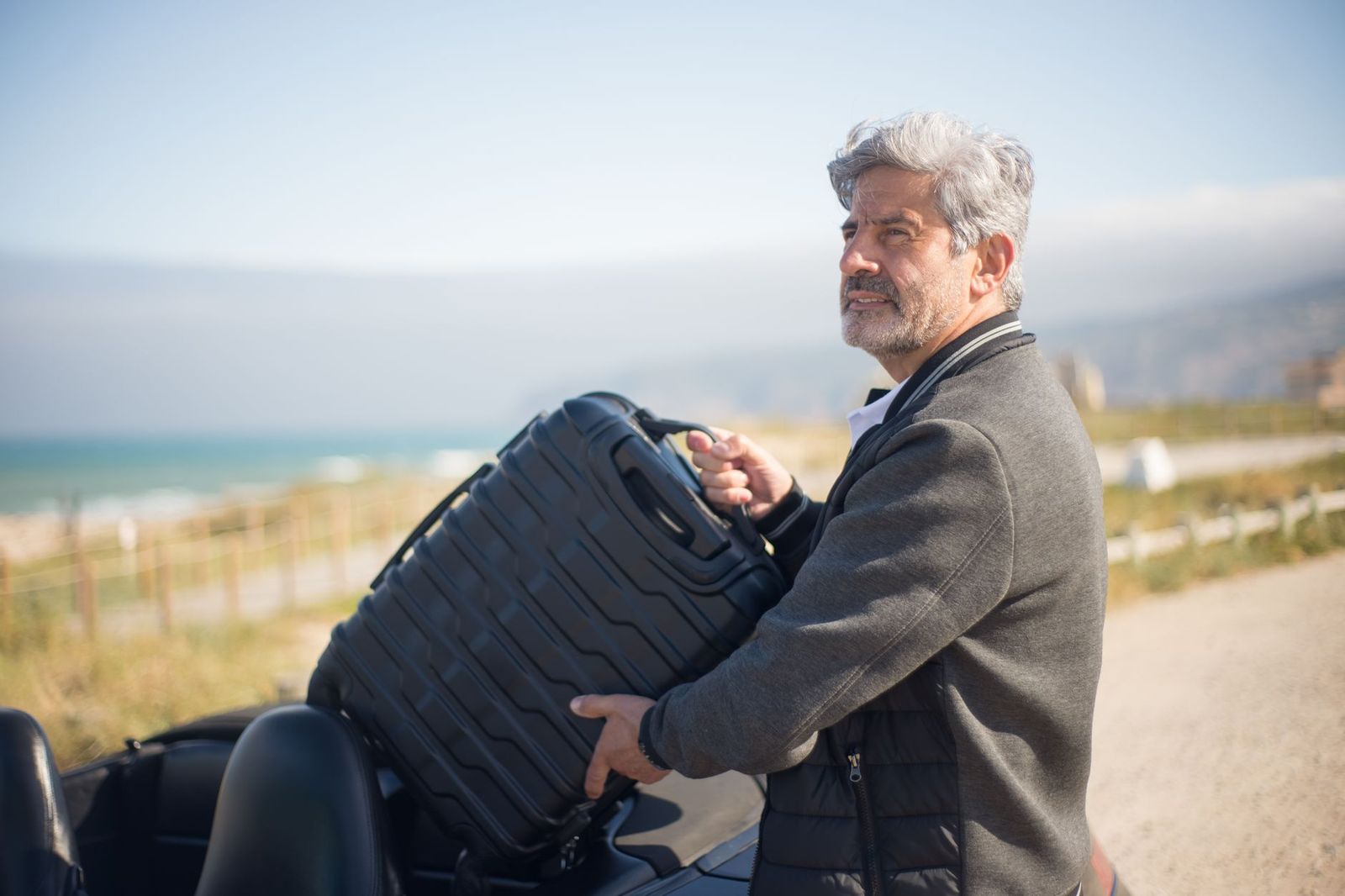 A chauffeur loading luggage: Pearson pickups include flight tracking and curbside meeting at the commercial pickup area