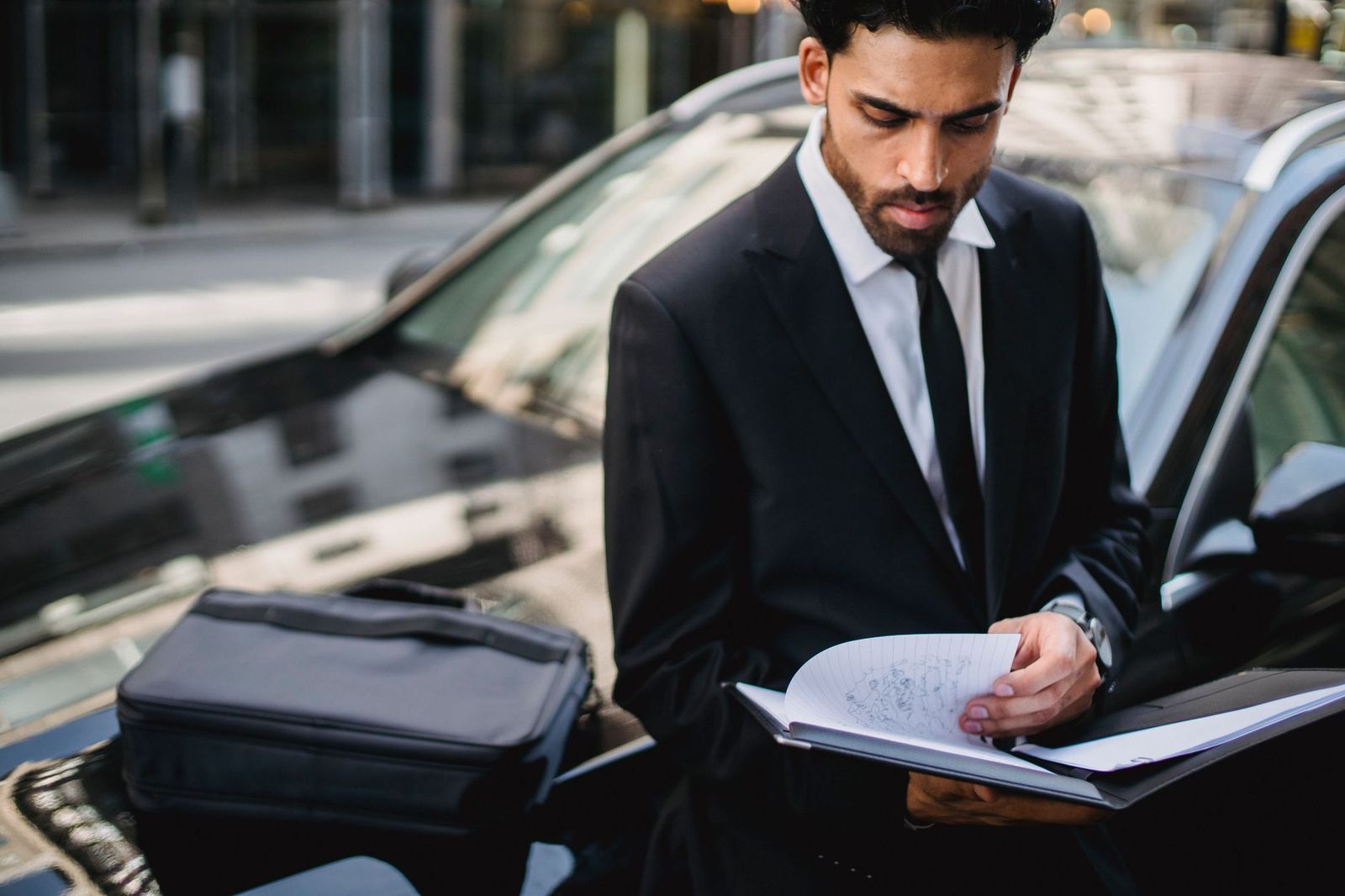 A chauffeur opening the rear door of a black sedan for a passenger in York Region
