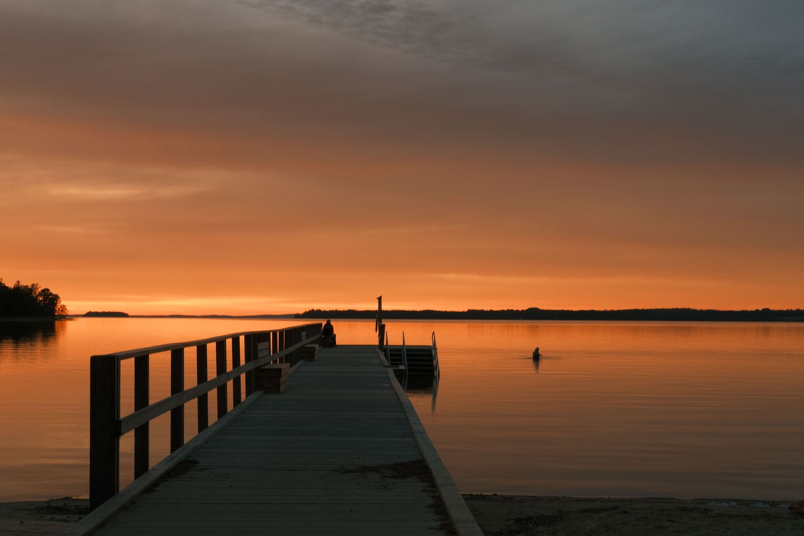 Muskoka chairs on a lake dock at sunset, the end of the drive north from Pearson