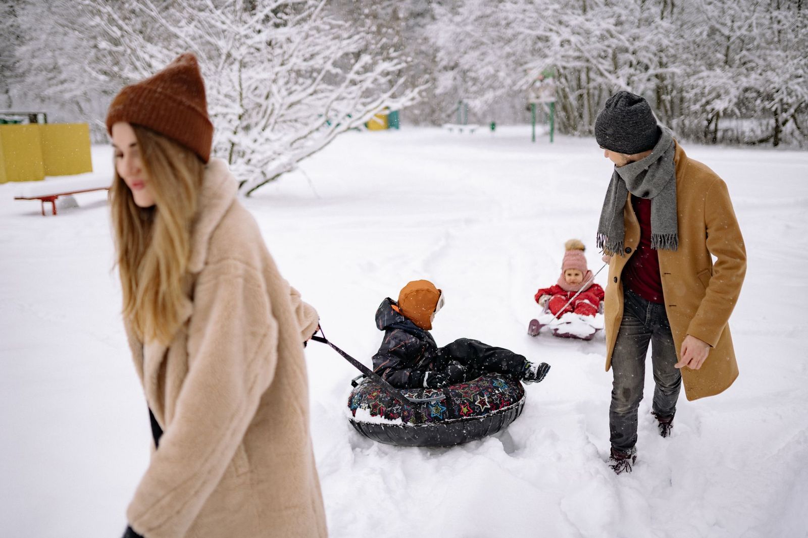 A family with snow tubes at Winterfest, with their chauffeured SUV waiting a short walk away