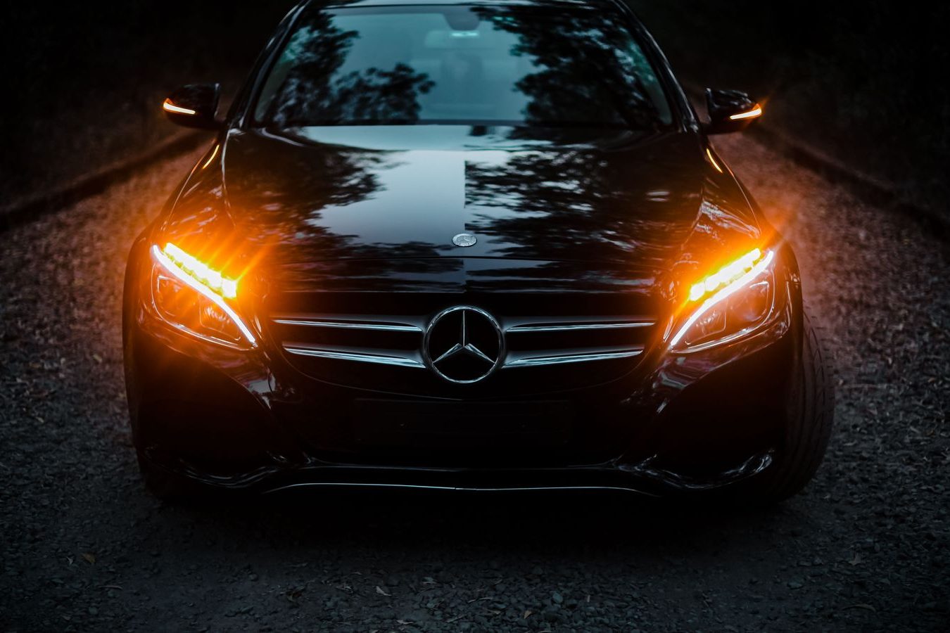 A black executive sedan waiting at night for guests leaving an evening show