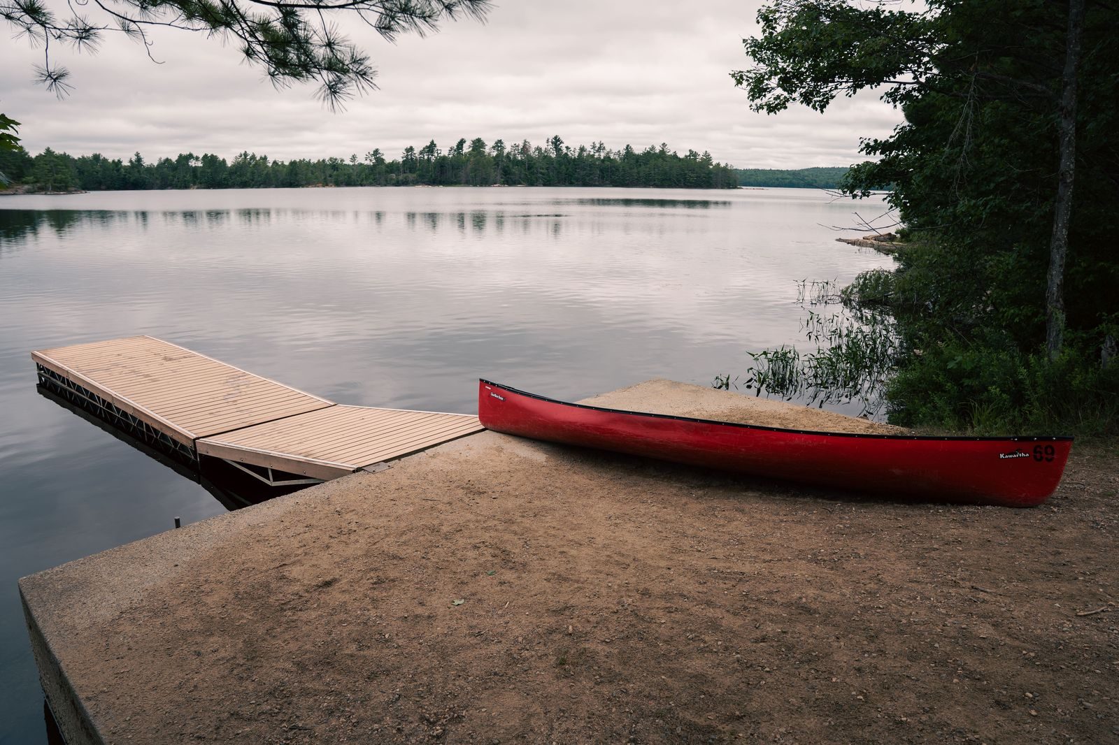 A cottage dock on a Muskoka lake in the morning light, the end of the journey for many private arrivals