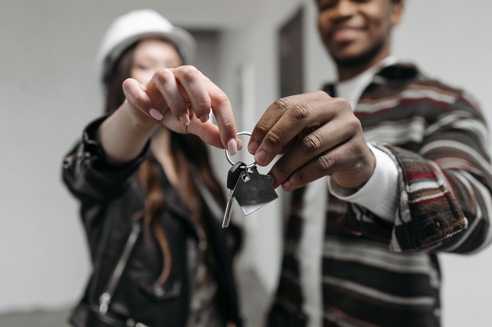 A chauffeur handing keys and a receipt to a passenger beside a black sedan