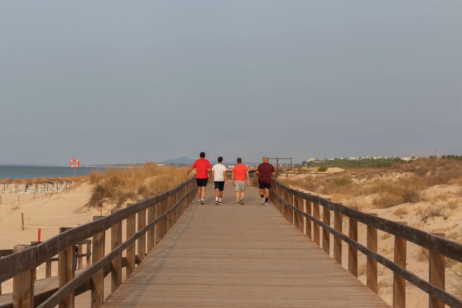 Visitors walking along a beach boardwalk in summer