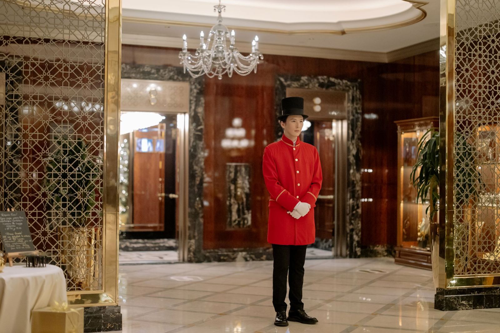 A chauffeur opening a car door at a hotel entrance in the city