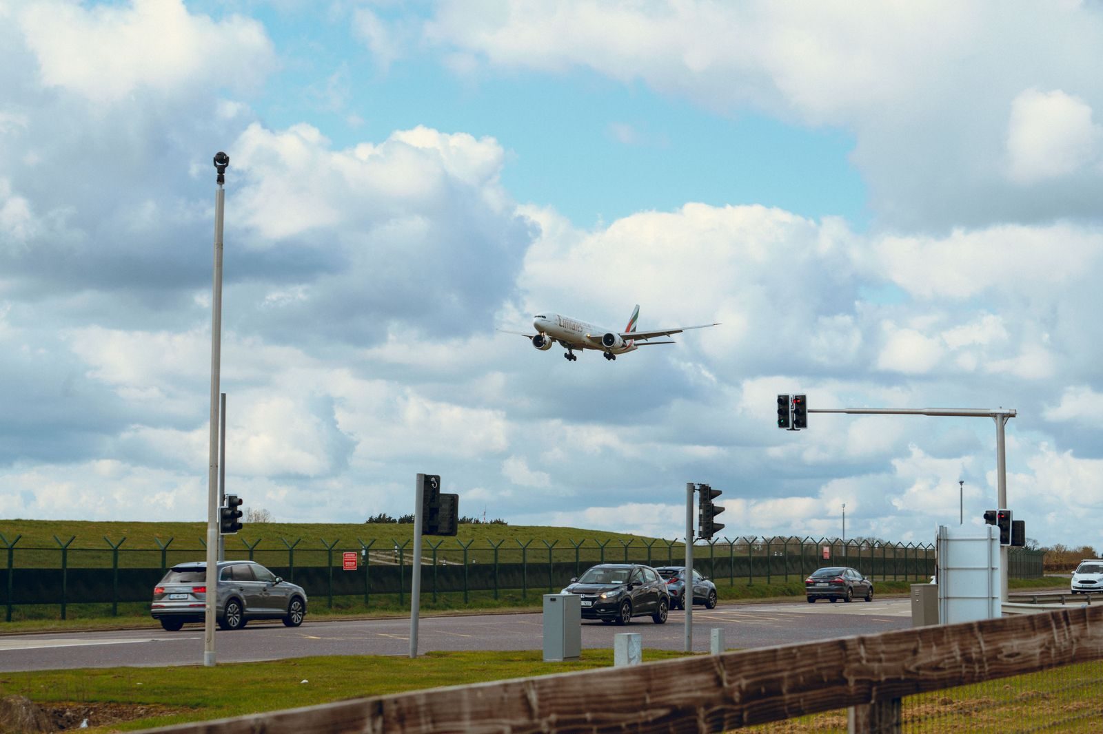 An aircraft taking off over a highway near the airport