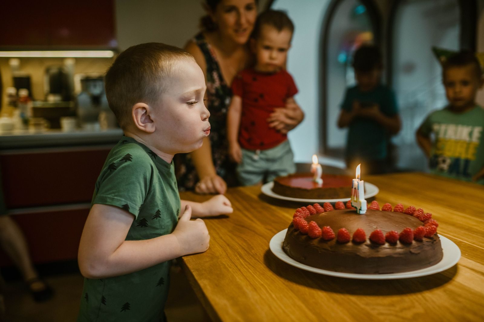 A birthday cake with lit candles on a party table