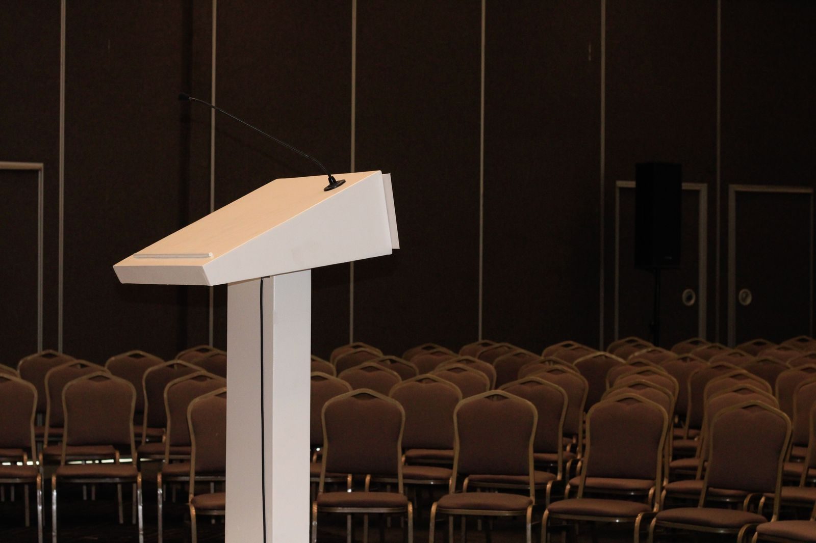 A conference audience seated in front of a lit stage