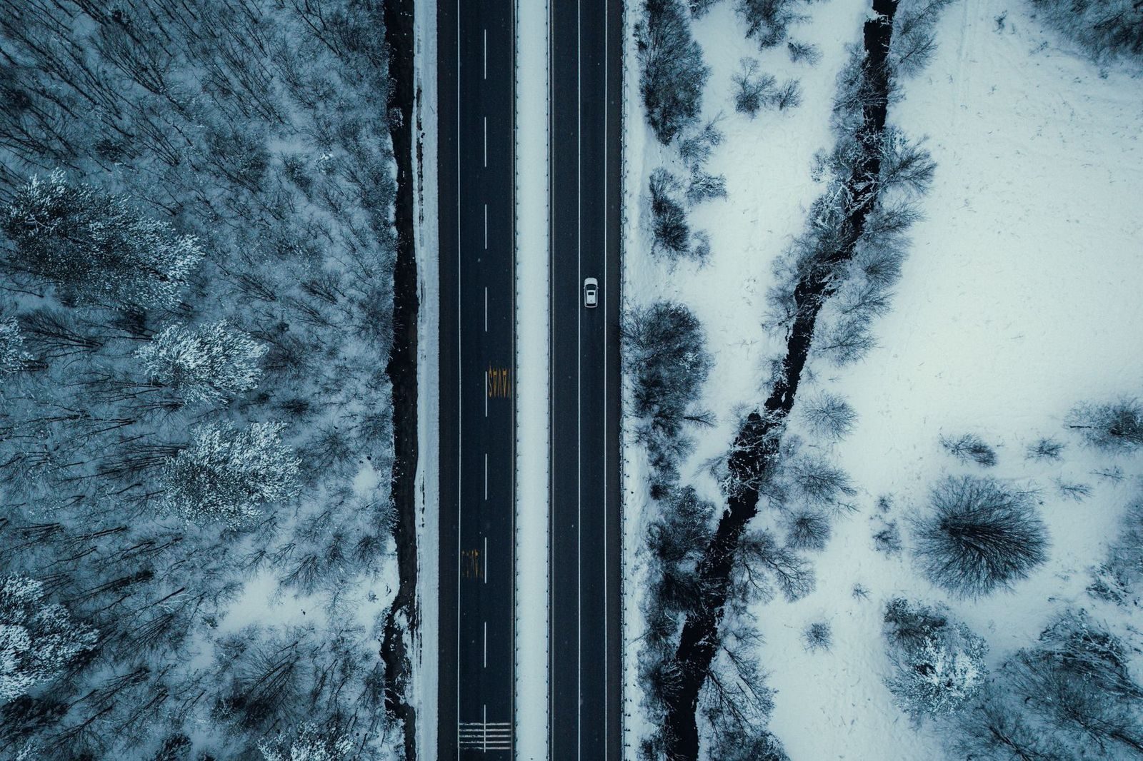 A black SUV driving a snowy highway toward Collingwood and Blue Mountain