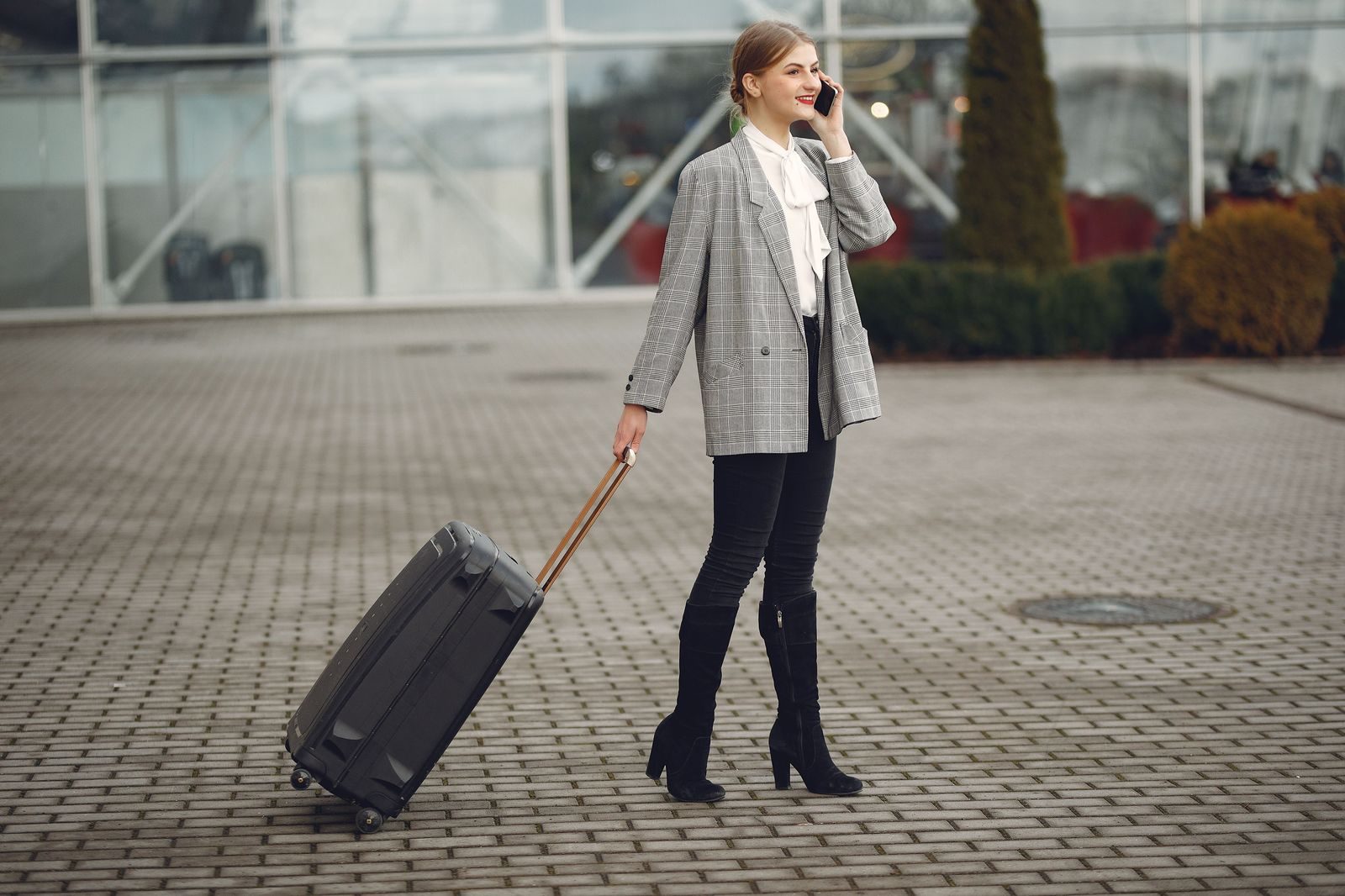 A business traveller with a wheeled suitcase heading for a car after a flight from the island airport