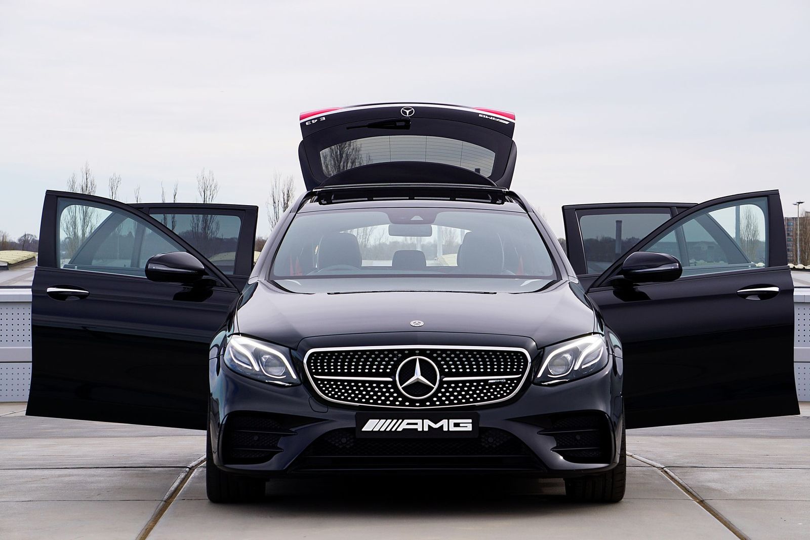 A chauffeur opening the rear door of a black car