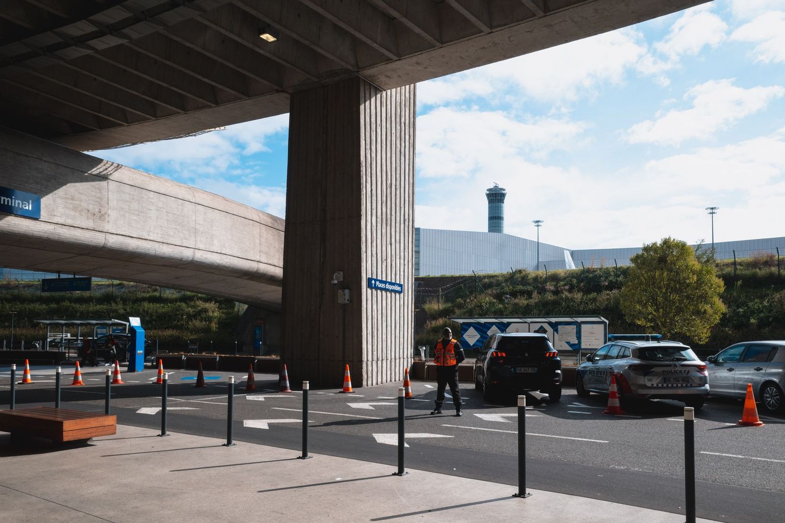 A black SUV at the curb of an airport terminal, the pickup point for flight-tracked black car runs