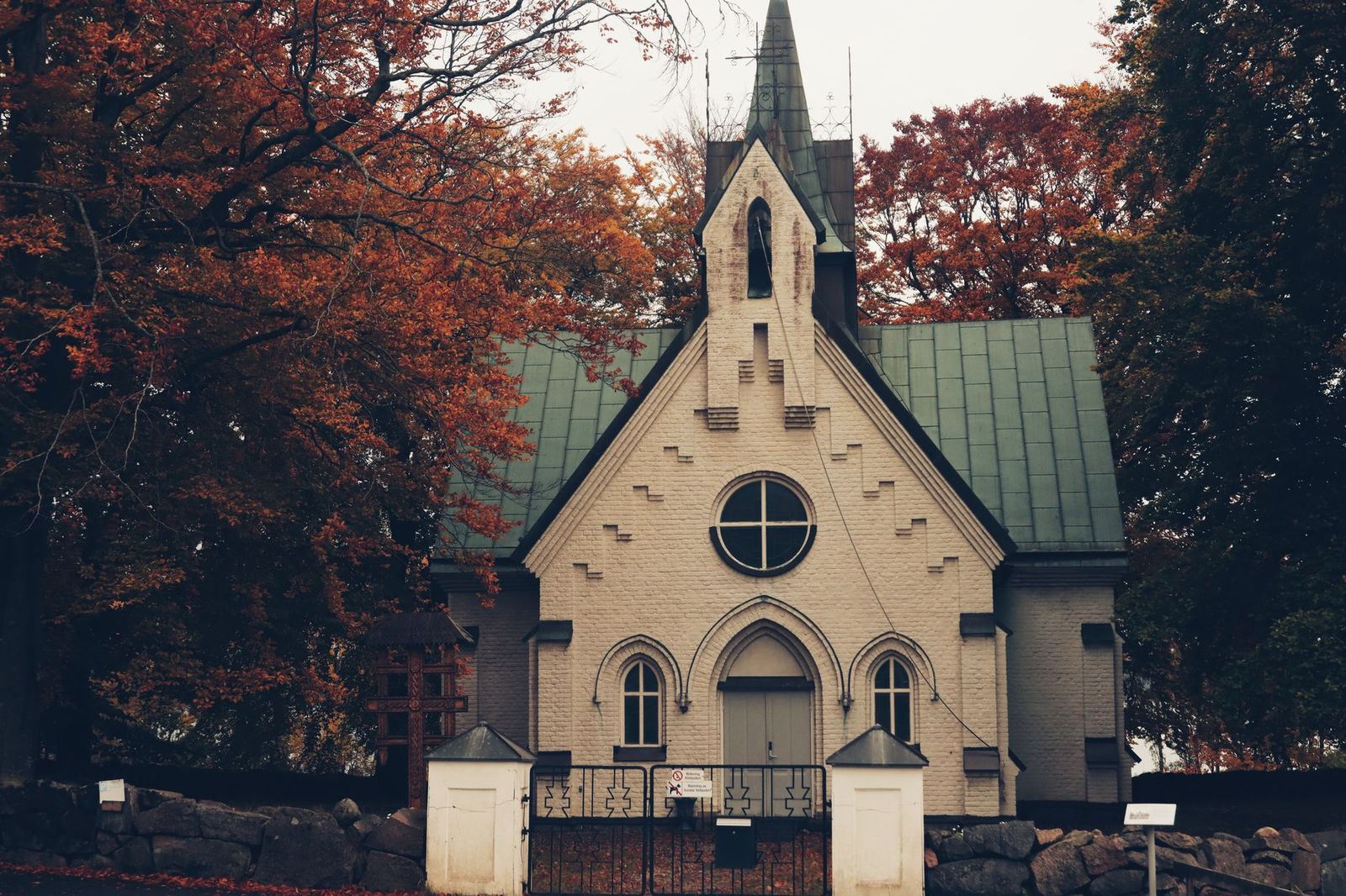 Black SUV waiting quietly outside a church on an autumn morning