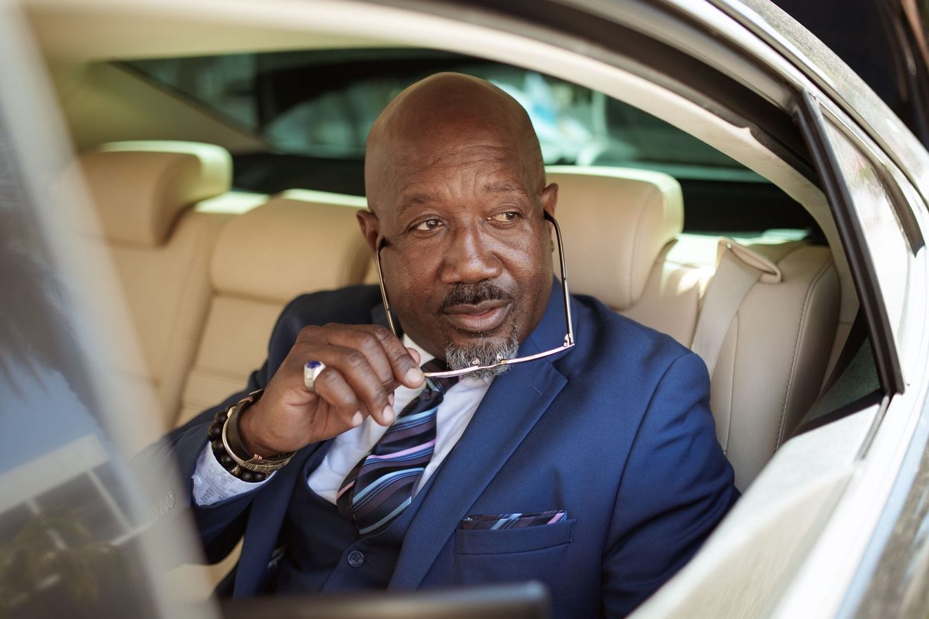 A chauffeur-driven black vehicle waits outside while the client is inside, still on the clock and still with you